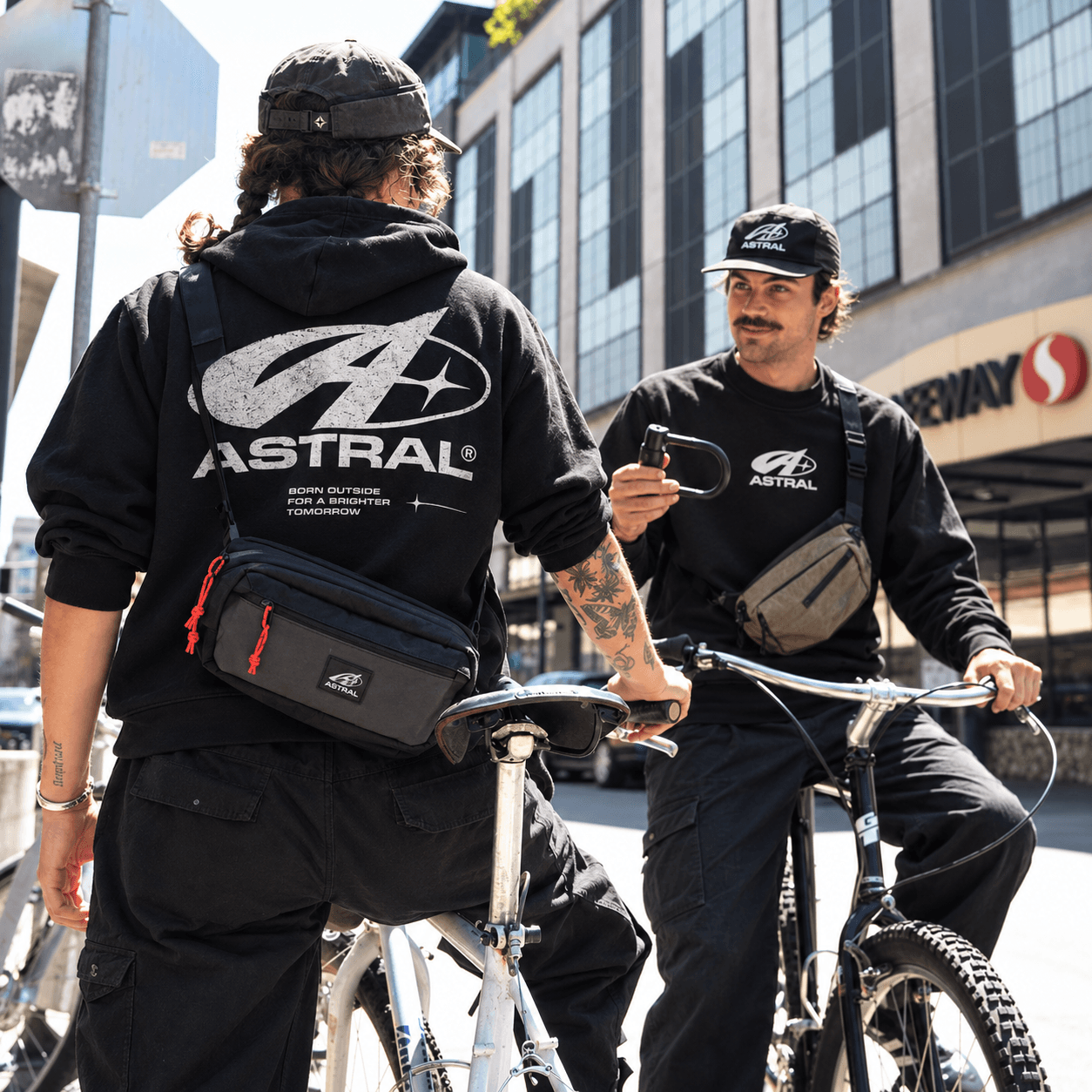 Dos ciclistas con poleras y morrales ASTRAL
